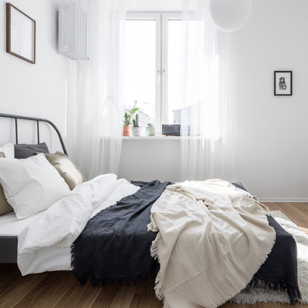 Minimalist student bedroom in white with metal bed frame