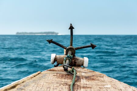 Close-up of an anchor on old wooden boat sailing on blue oceanの写真素材
