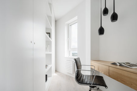 Corner home office in white with wooden desk and big wardrobe