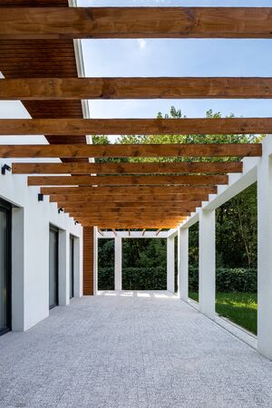 Modern cobblestone patio with wooden ceiling in a modern white houseの写真素材