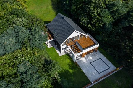 Aerial view of stylish house with wooden balcony and big cobblestone drivewayの写真素材