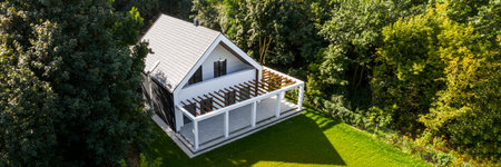 Aerial view of modern house exterior with cobblestone patio and green backyard, panoramaの写真素材