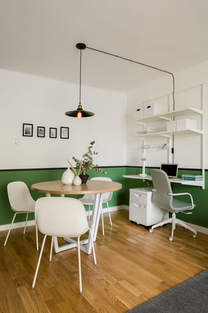 Small apartment with dining area with table and home office with desk in one roomの写真素材