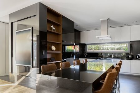 Elegant and spacious kitchen in black and white, with dining area for eightの写真素材