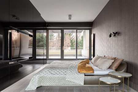 Elegant bedroom with big bed, and window wall to balconyの写真素材
