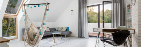Panorama of stylish attic living room with hammock seat, balcony and desk to study