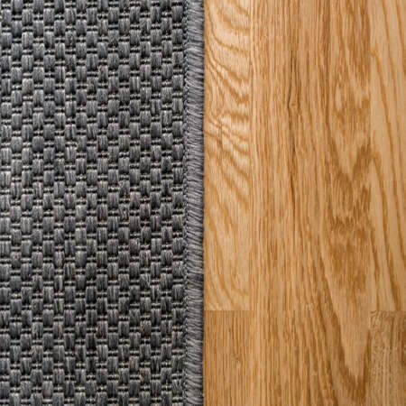 Close-up on architectural detail, simple gray carpet and wooden floor panelの写真素材