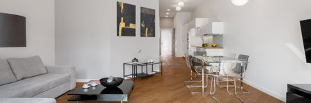 Panorama of spacious and modern apartment with wooden floor and living room with dining area open to...
