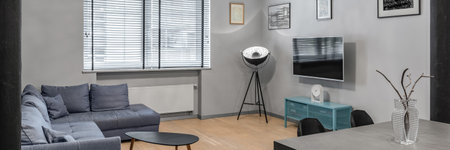 Panorama of stylish living room with sofa, modern lamp, tv and dining tableの写真素材