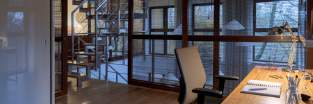 Panorama of two-story apartment with modern stairs next to home office room with window wall