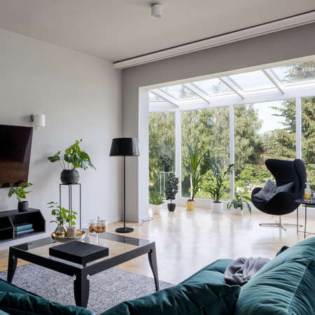 Bright, stylish and elegant living room with nice oriel window with forest viewの写真素材