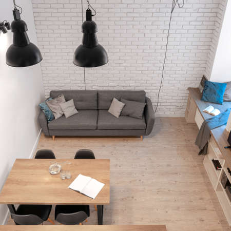 Top view of small and stylish living room with white brick on the wall and wooden floorの写真素材