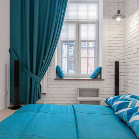 Modern and simple white and blue bedroom with big window and decorative curtainsの写真素材