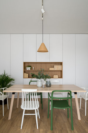 Modern designed dining room with simple, wooden table and various and colorful chairsの写真素材