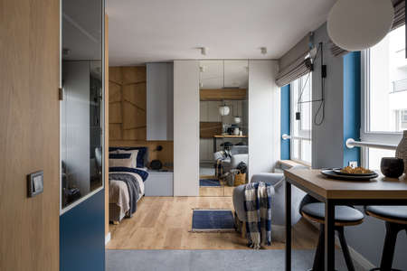 Modern and stylish single studio apartment with bedroom open to kitchen area with tableの写真素材