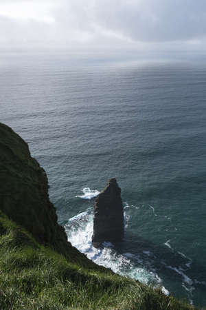Single sea stack in calm sea by Cliffs of Moher, Irelandの写真素材
