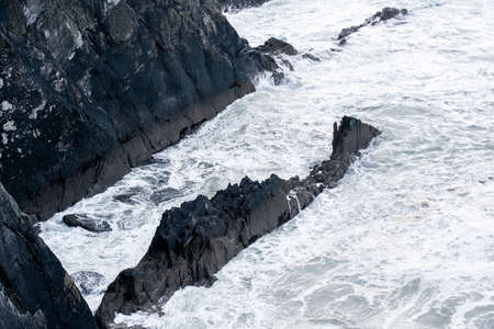Big waves crashing on sea stack and rocky cliffsの写真素材