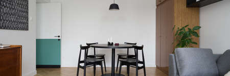 Panorama of eclectic style living room with modern dining table with four chairs and vintage wardrobeの写真素材