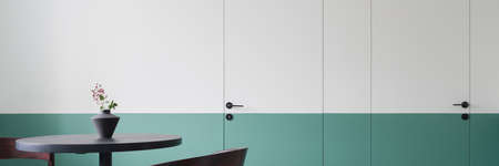 Panorama of modern architecture design with half green and white doors and wall in stylish dining room with dark table with vaseの写真素材
