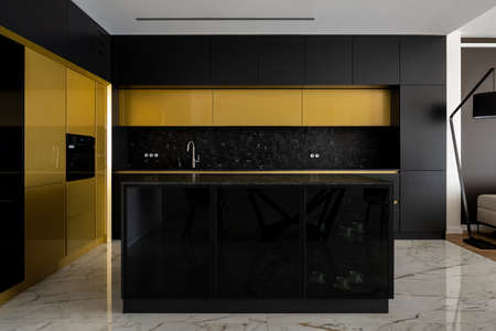 Luxury kitchen in black and gold with kitchen island and marble floorの写真素材