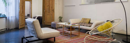 Panorama of vintage and eccentric living room with old, wooden doors, stylish furniture and artistic decorationsの写真素材