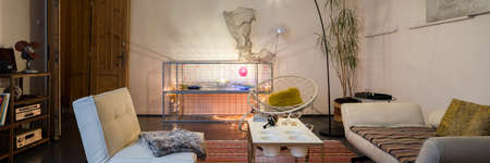 Panorama of eclectic decorated living room with stylish lighting, vintage furniture and creative decorationsの写真素材