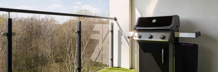 Panorama of spacious terrace with stylish glass balustrade and modern gas grillの写真素材