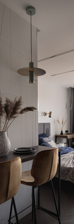 Vertical panorama of stylish table with two yellow chairs under decorative lamp next to bedroomの写真素材