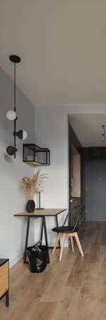 Vertical panorama of stylish and small home office in apartment interior with decorative lighting, wooden floorの写真素材