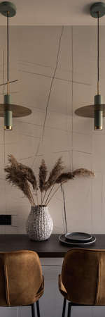Vertical panorama of small table with decorations under two modern lamps and with two stylish, golden chairsの写真素材