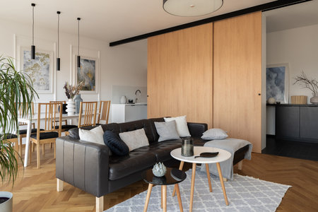 Black corner sofa and two coffee table in modern living room open to dining area and kitchenの写真素材