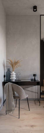 Vertical panorama of decorated black desk and gray chair in modern home office roomの写真素材