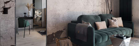 Panorama of green sofa in small living room next to bedroom with desk and chairの写真素材
