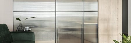 Panorama of modern tempered glass wall in living room with green sofaの写真素材