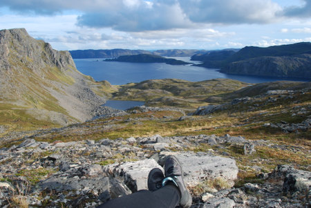 A hiker sitting by Duksfjorden on Mageroya Island, Norwayの写真素材