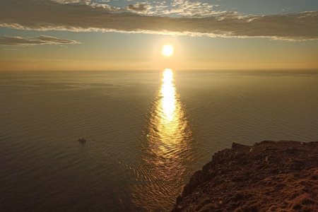 The midnight sun reflected in the ocean, view from King's view in Nordkapp (North Cape) in Mageroya Island, Norwayの写真素材