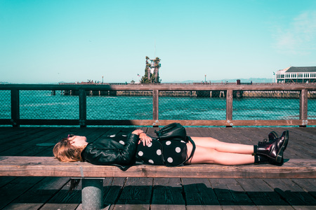 Photo of Girl Lying Down on a Bench at San Francisco, Californiaの写真素材