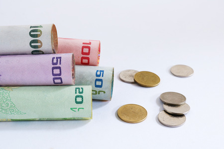 banknote roll and coins scatter thailandの写真素材