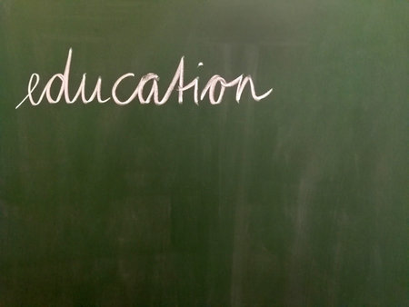 The handwritten word education on a green chalkboard.