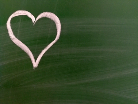 A handpainted heart on a green chalkboard. Background.の写真素材