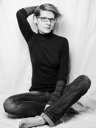 Young woman with short hair and glasses in black and whiteの写真素材