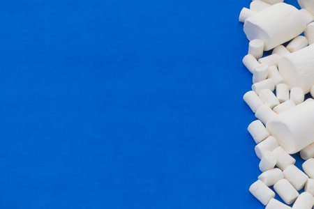 group of small and big marshmallows covering the right side of a blue background