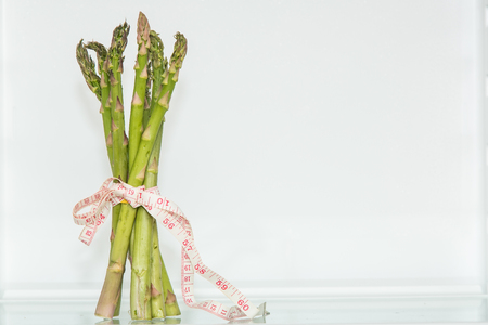 Garden asparagus with measuring tape. Healthy eating. Healthy lifestyle. Diet. Source of vitamins. Vegetarian. Weight loss.の写真素材