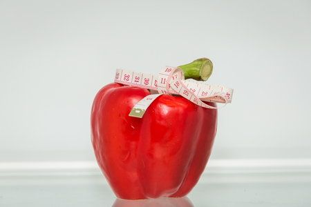 Red sweet pepper with measuring tape. Healthy eating. Healthy lifestyle. Diet. Source of vitamins. Vegetarian. Weight lossの写真素材