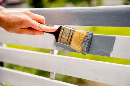 Hand painting white timber boards with grey paint using paint brush.の写真素材