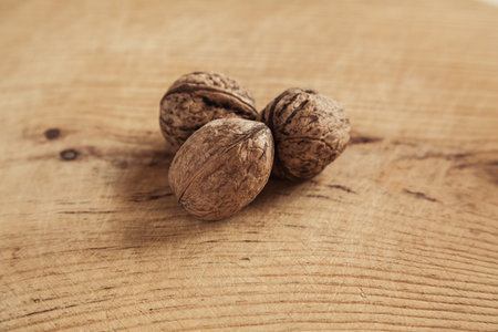 Three walnut on wooden background. Shallow depth of field.