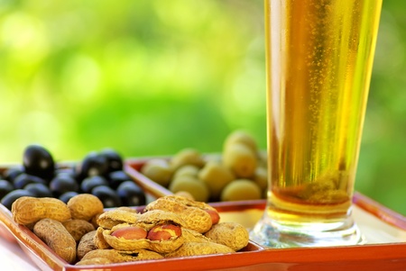 beer glass with peanuts and olivesの写真素材