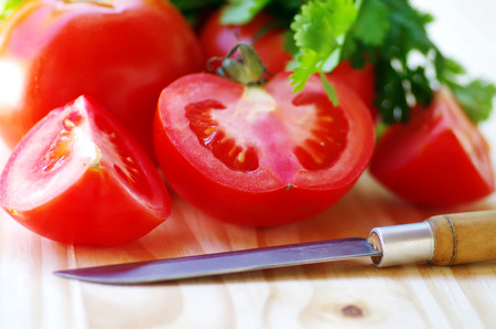ripe tomato sliced  and knife on tableの写真素材