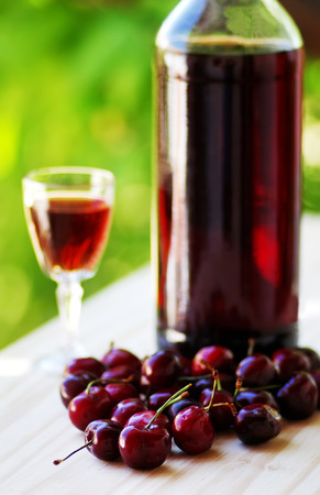 Cherry fruits and bottle of liqueurの写真素材