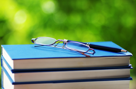 books and glasses on green backgroundの写真素材